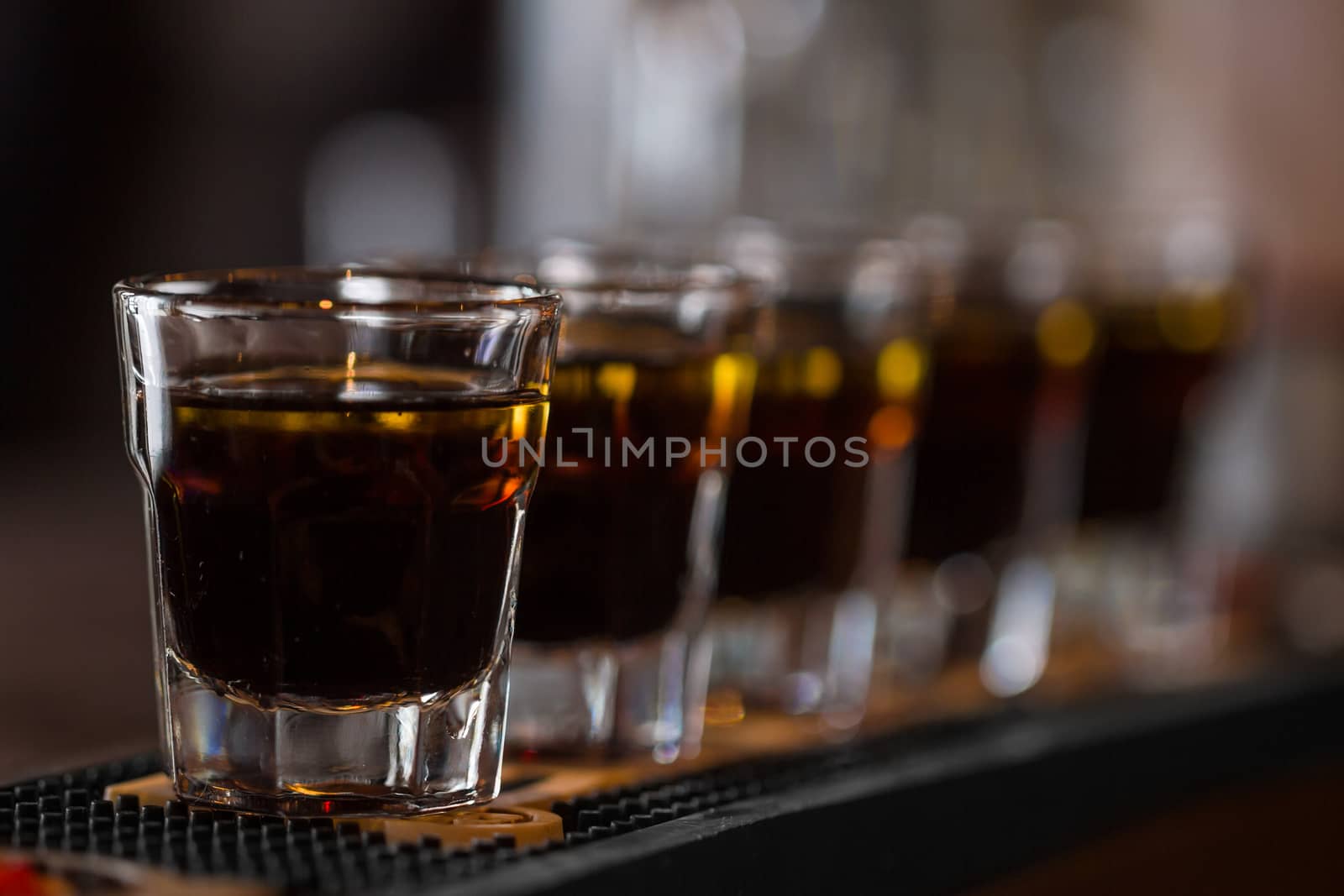 Whisky shot drinks in row. Alcoholic shots in nightclub