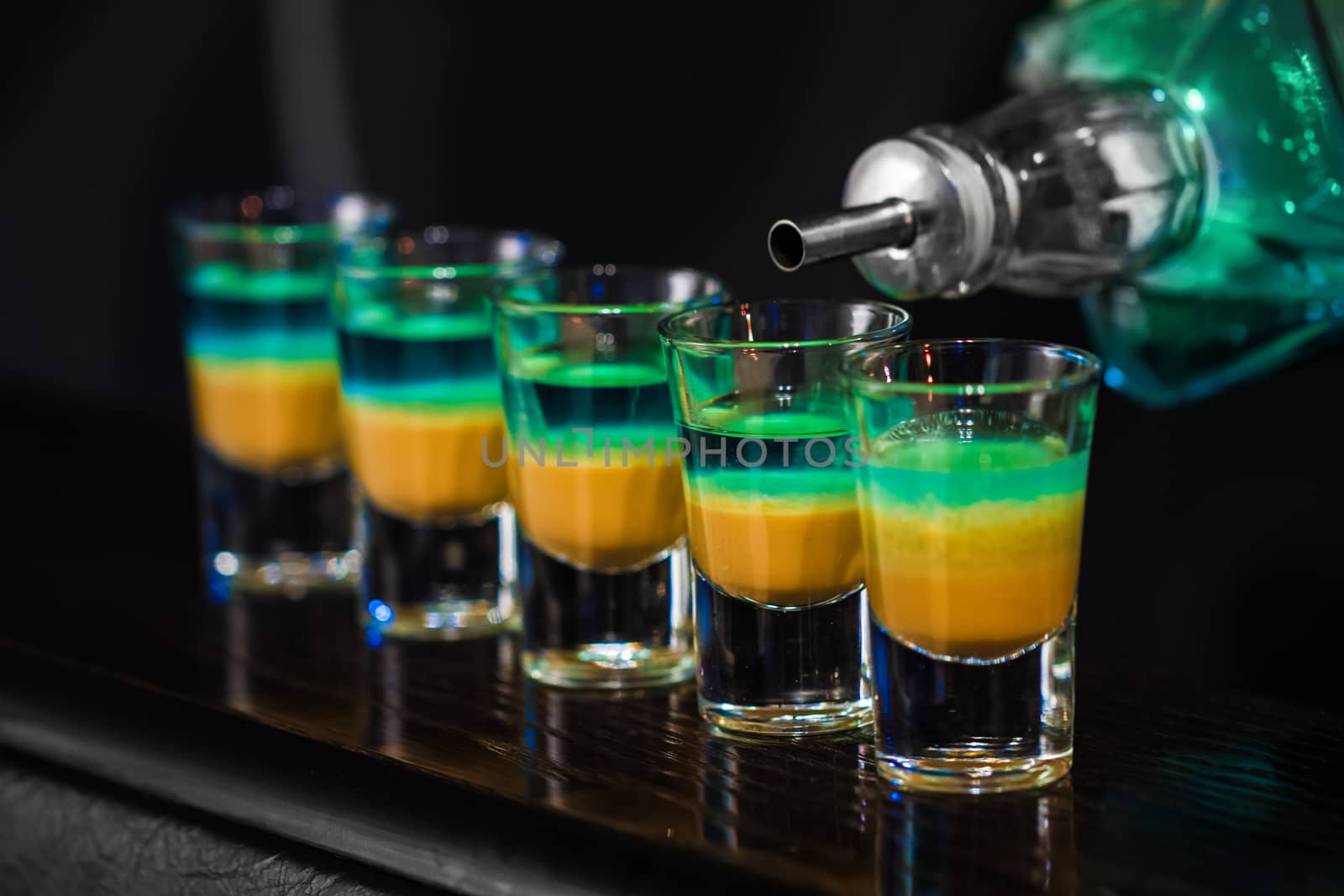 Barman make alcoholic shots in nightclub