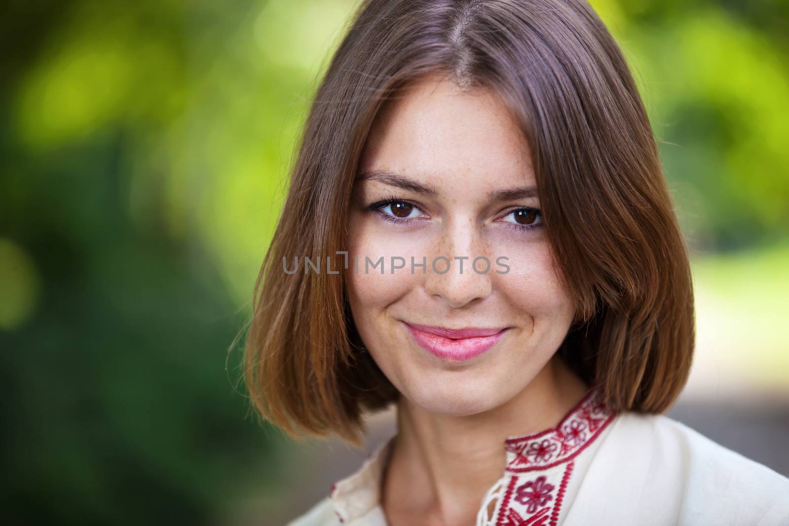 Young beautiful woman in summer park smiling by photobac
