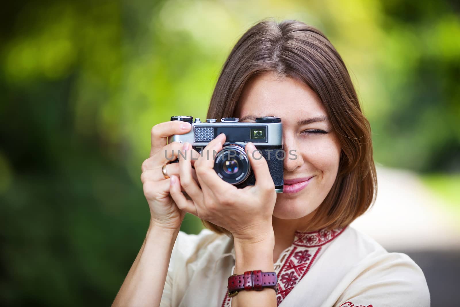 Young woman taking picture with retro camera by photobac