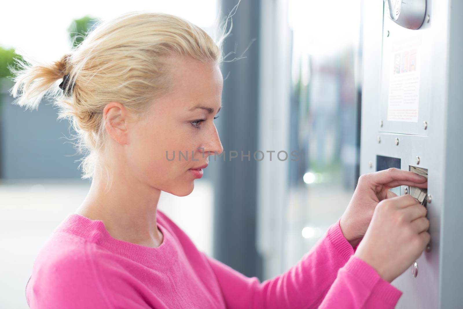 Woman inserting coin in the vending machine. by kasto