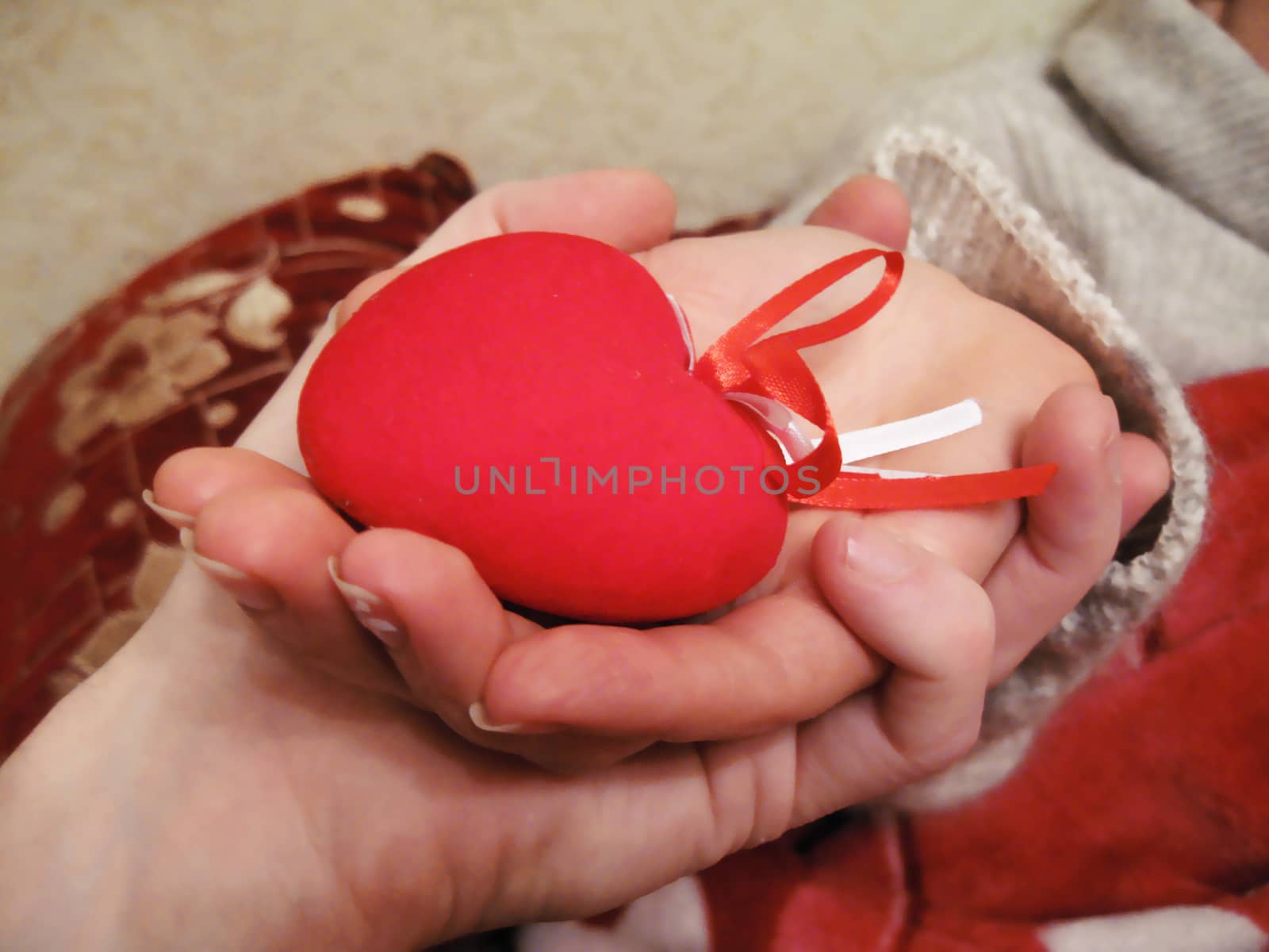 Valentine red heart in woman and man hands by scullery