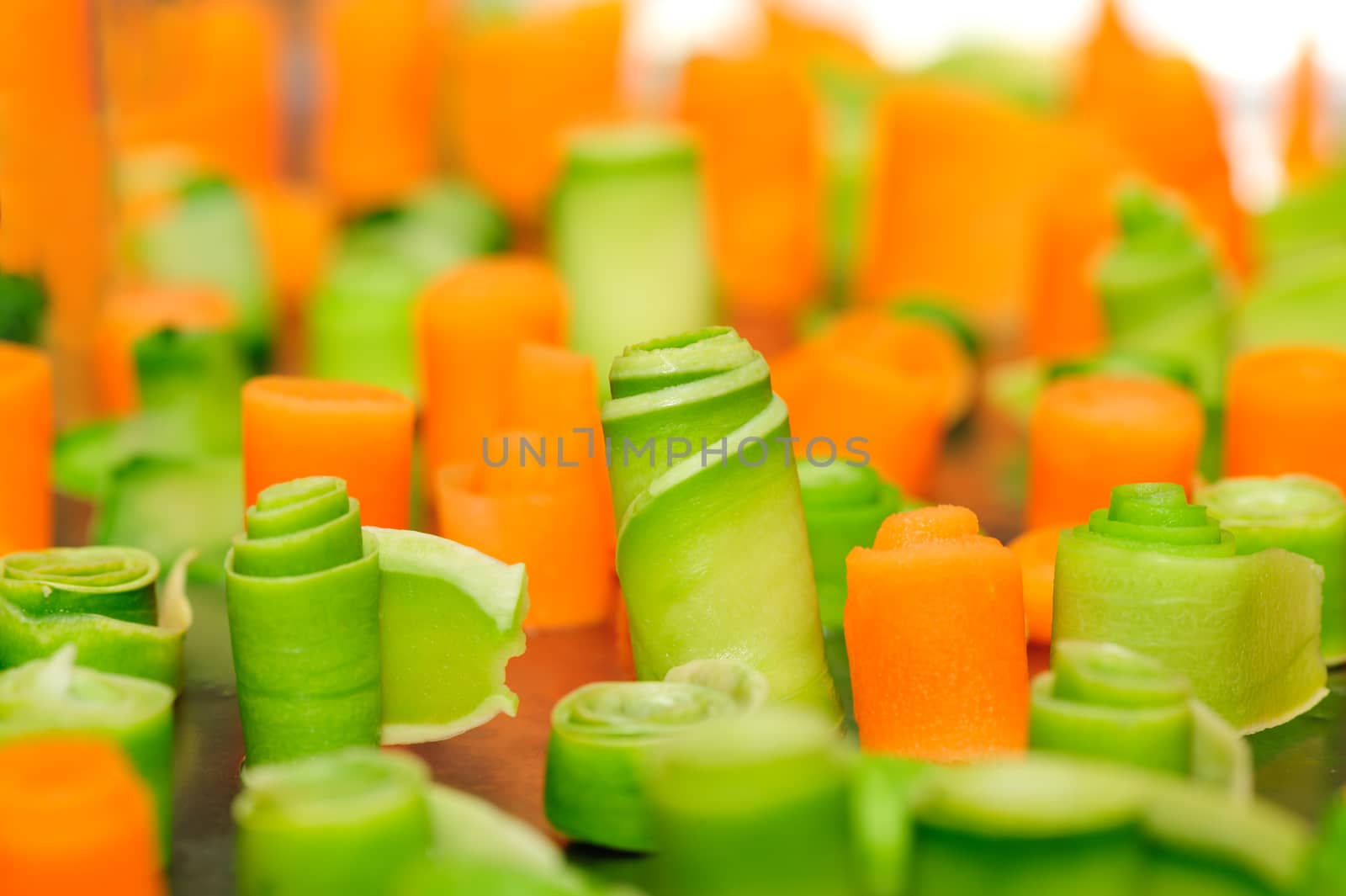 food decoration, twisted slices of carrot and zucchini on stainless steel tray