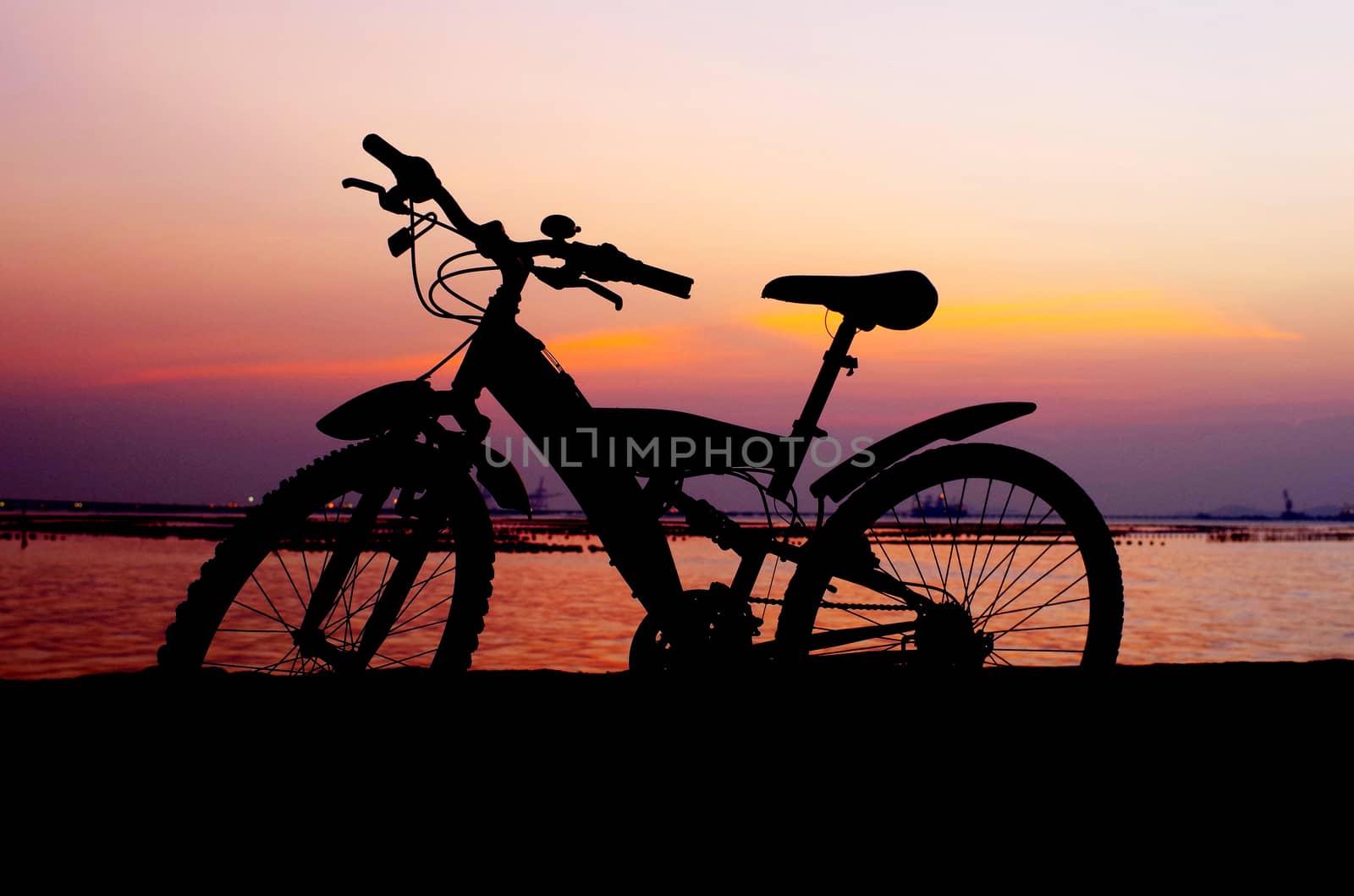 Mountain bike silhouette with sunset sky by pixbox77