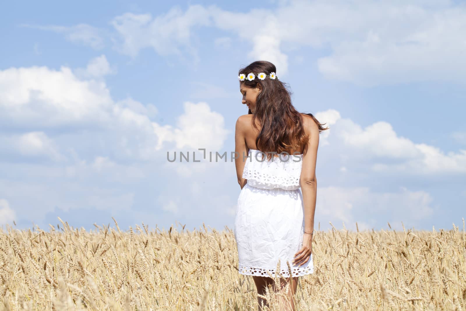 Beautiful young woman in a wheat golden field