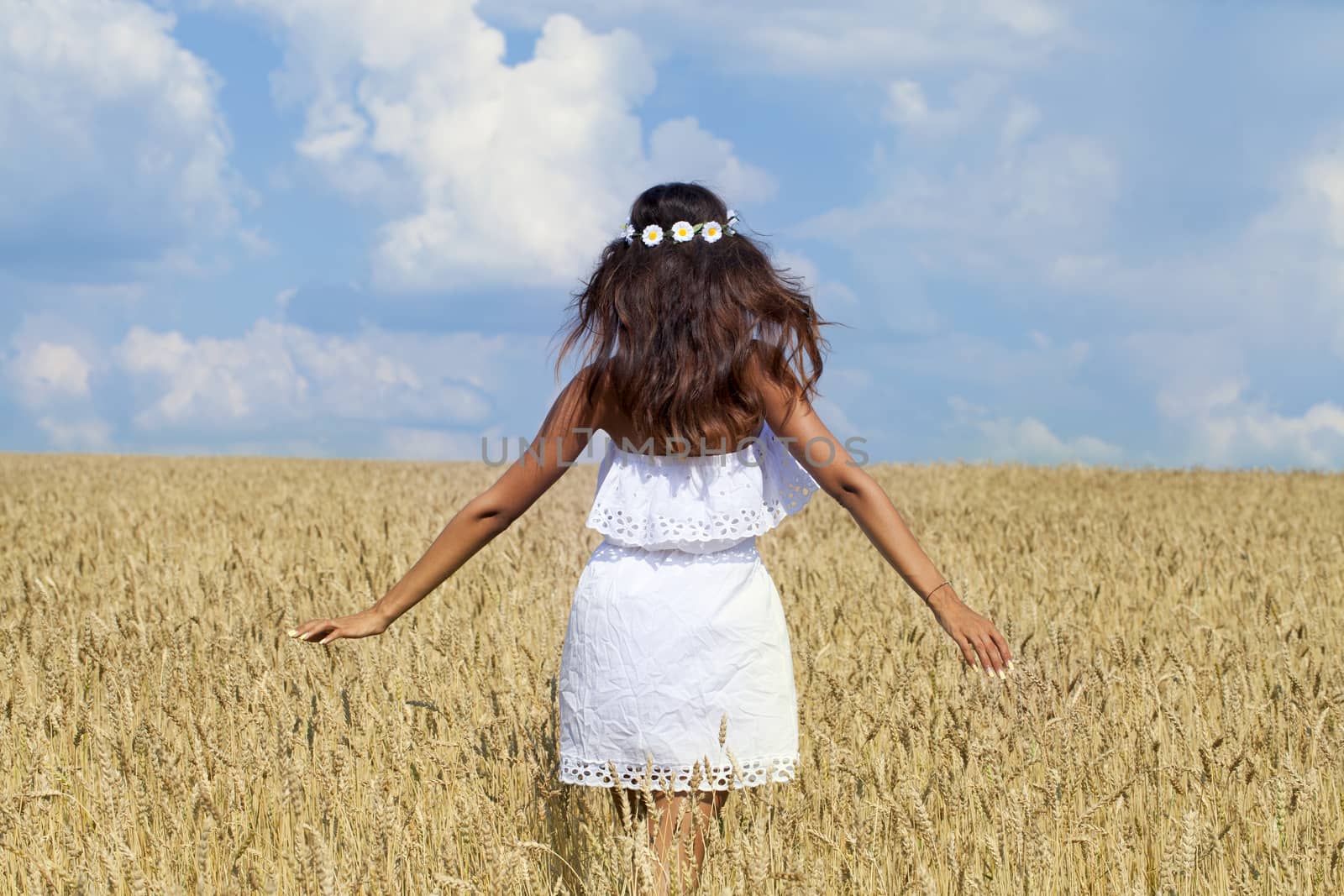 Beautiful young woman in a wheat golden field