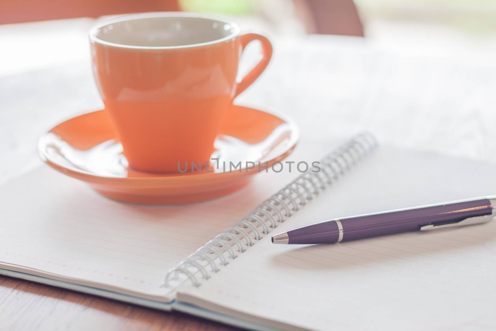 Coffee cup, pen and notebook on wooden table, stock photo