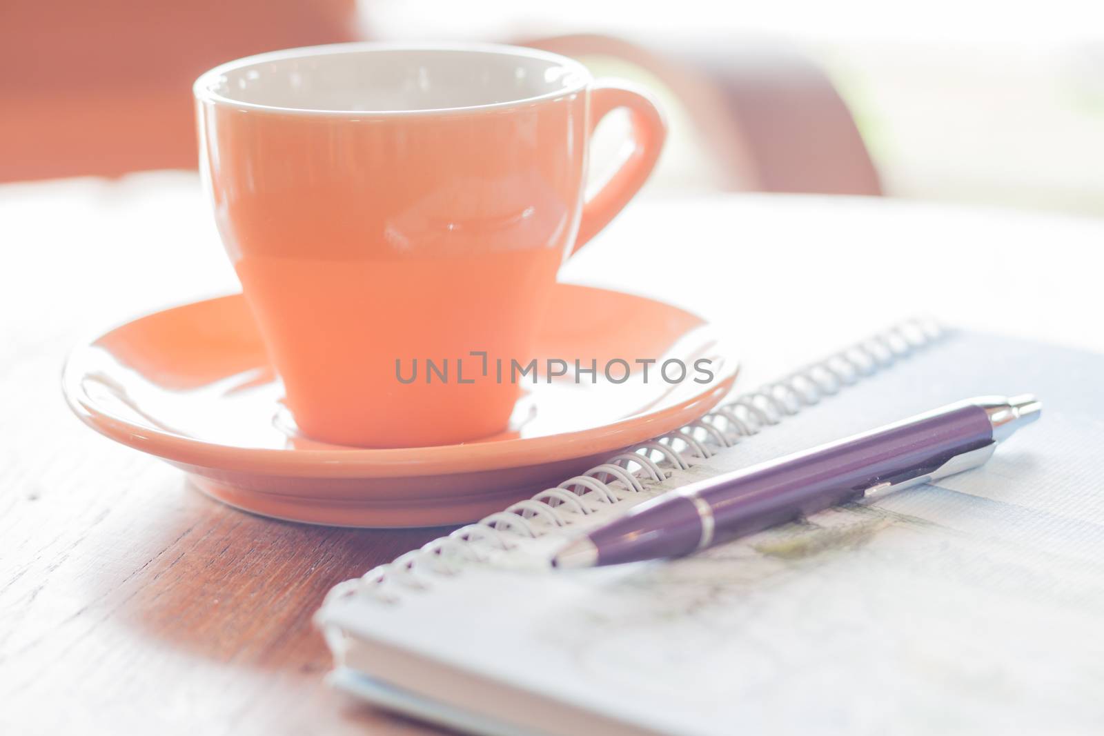 Pen and spiral notebook with coffee cup, stock photo