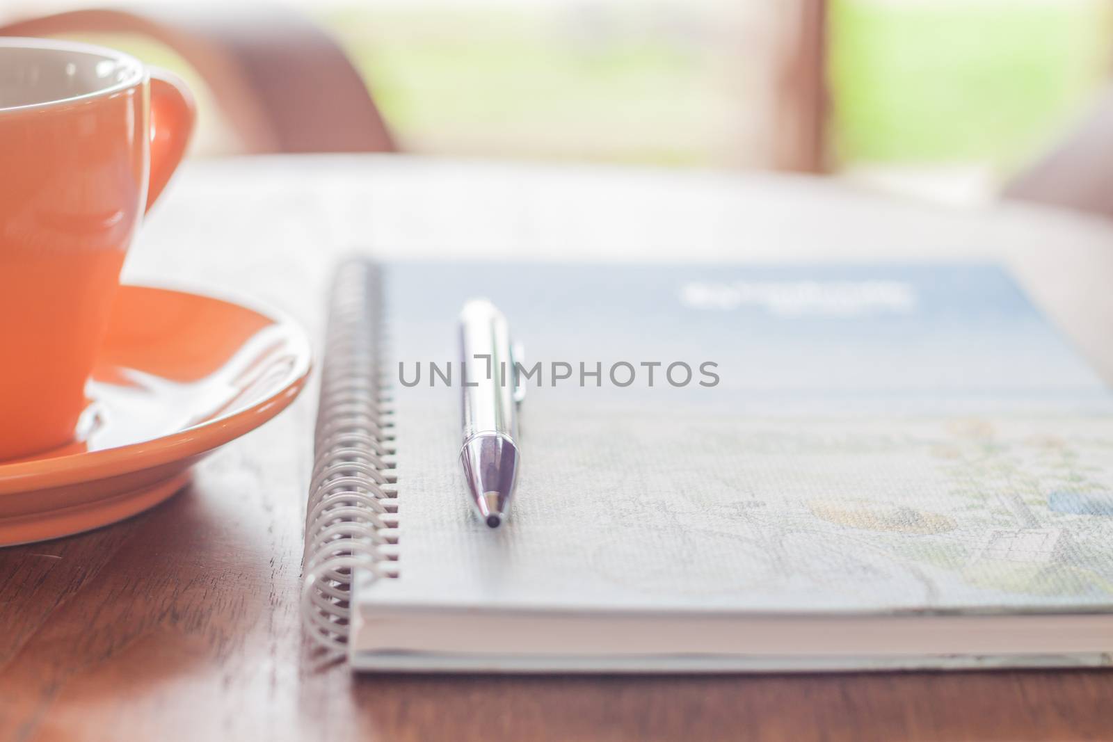 Coffee cup with pen and spiral notebook, stock photo