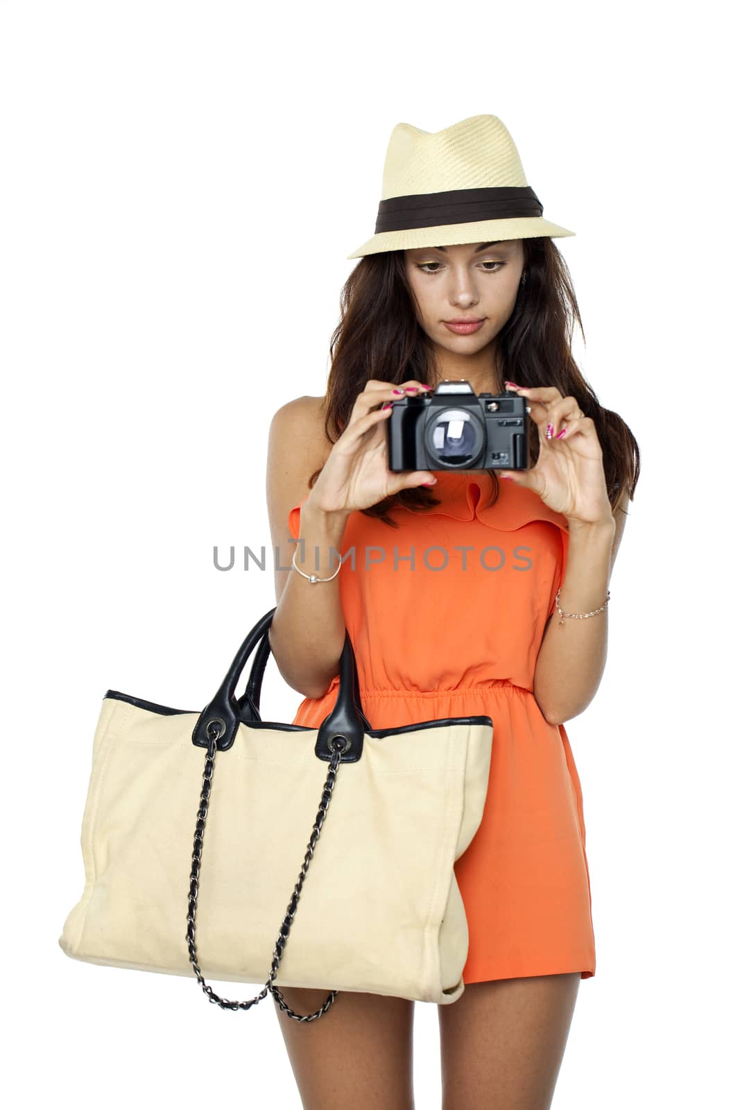 Happy young woman using a camera to take photo, isolated on white