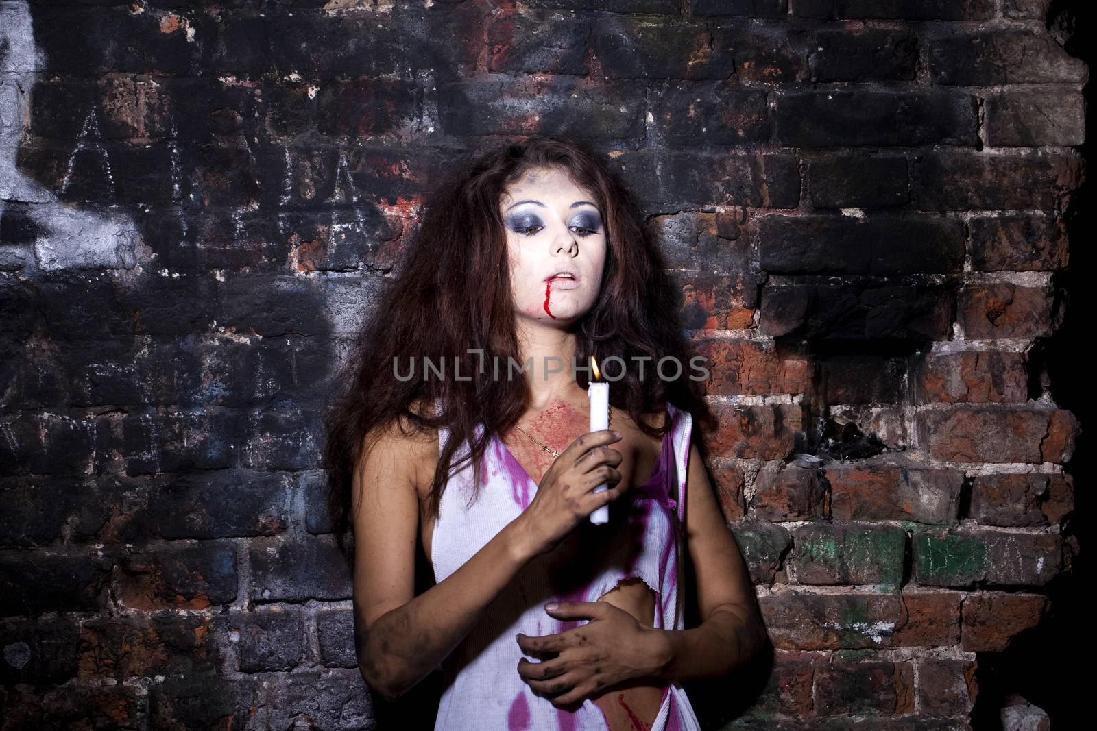 Frightened girl with a candle in hands