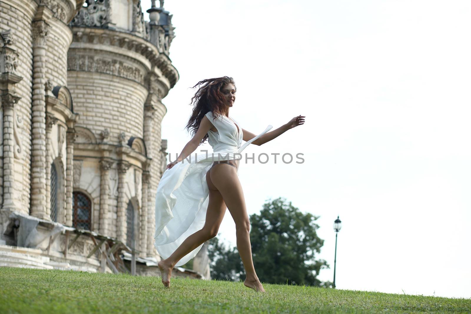 Sexy woman in a white dress on a background of the church