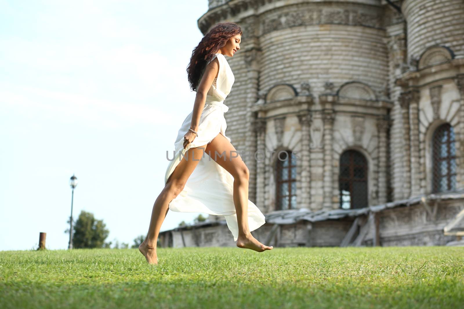 Sexy woman in a white dress on a background of the church