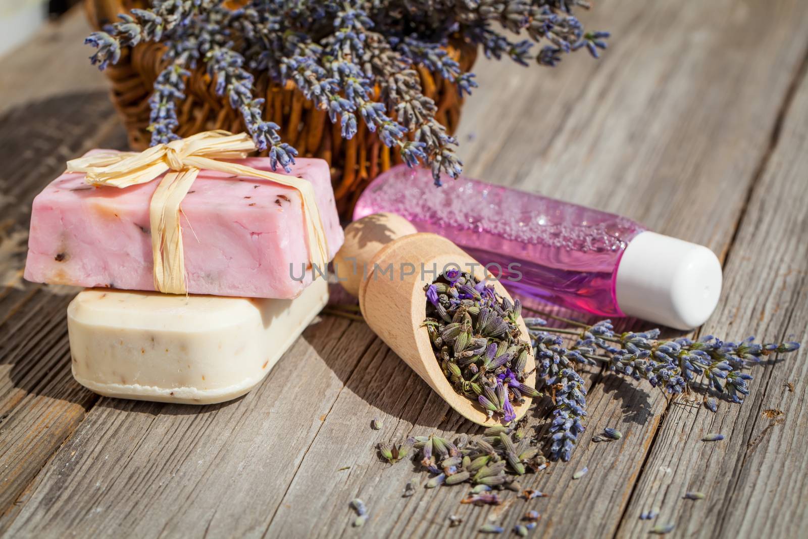Spa and wellness setting. Natural handmade lavender oil and soap and fresh lavender flowers on wooden background