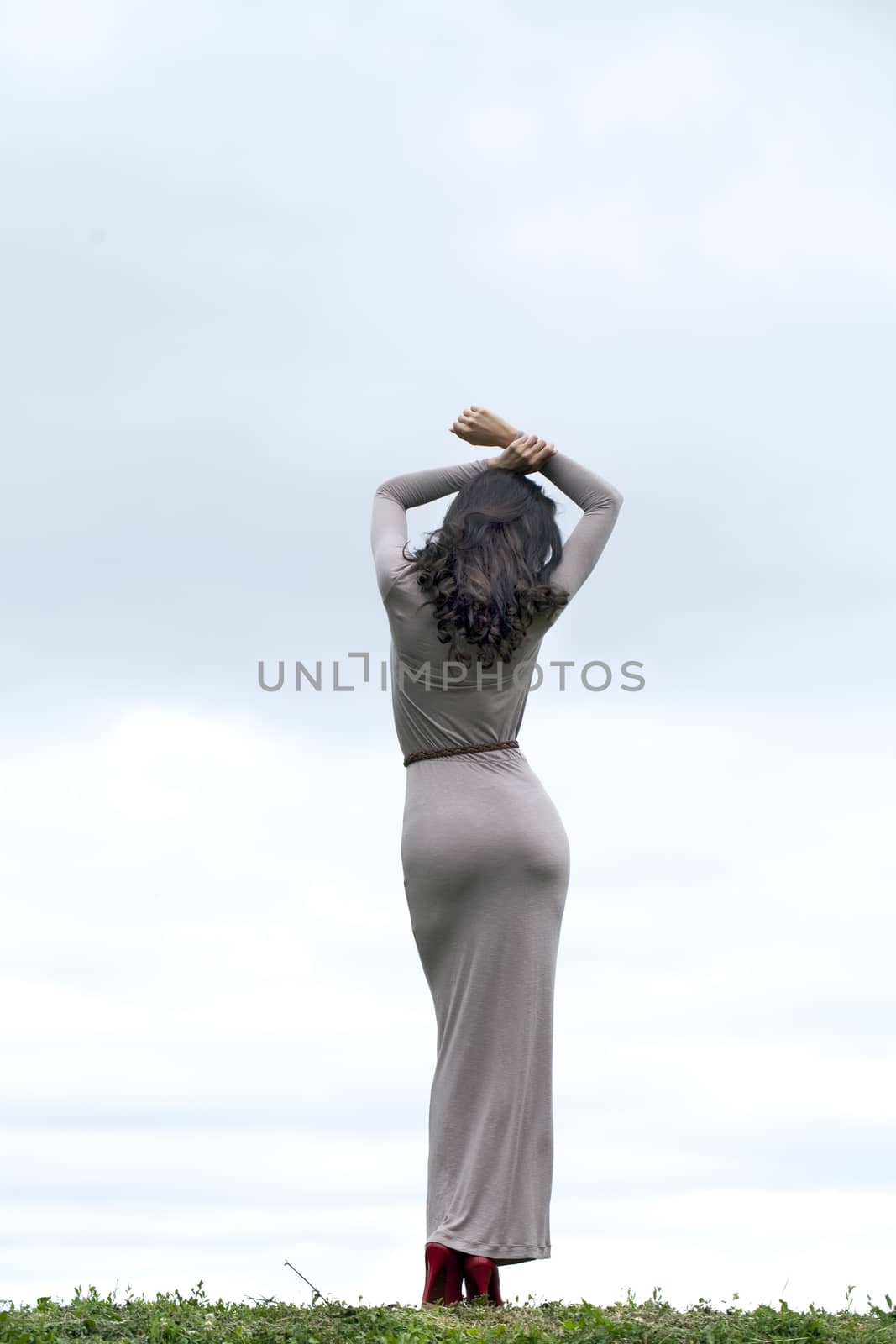 Full growth, beautiful young woman in sexy long gray dress