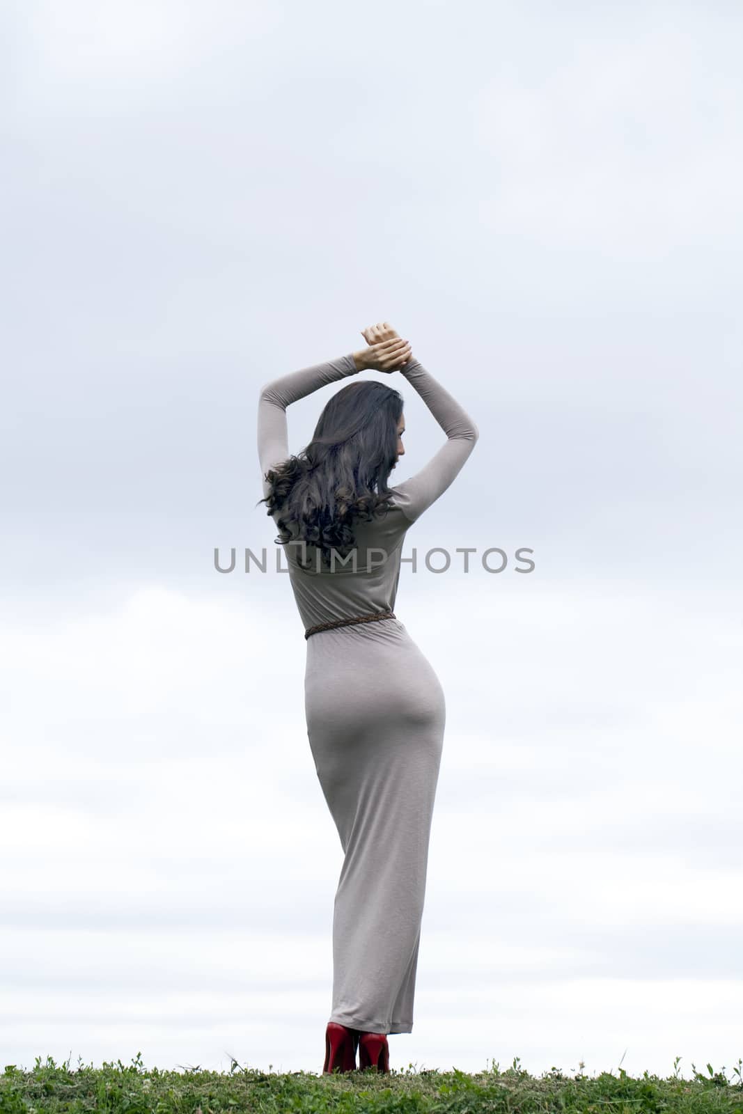 Full growth, beautiful young woman in sexy long gray dress