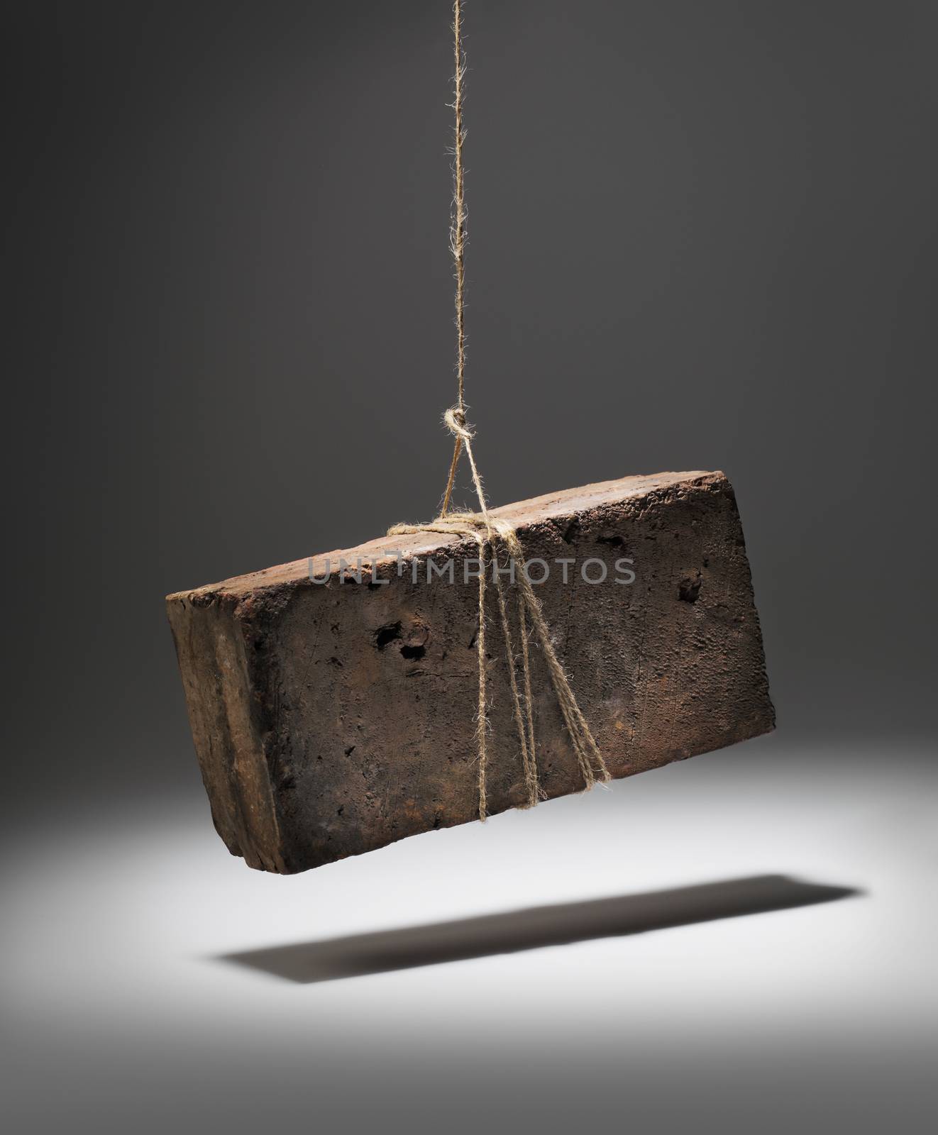 Old worn and weathered brick hanging on a string.