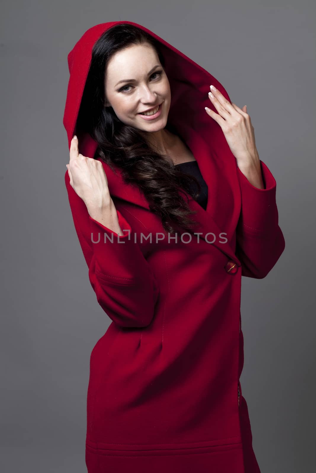Beautiful young woman in a red coat with hood