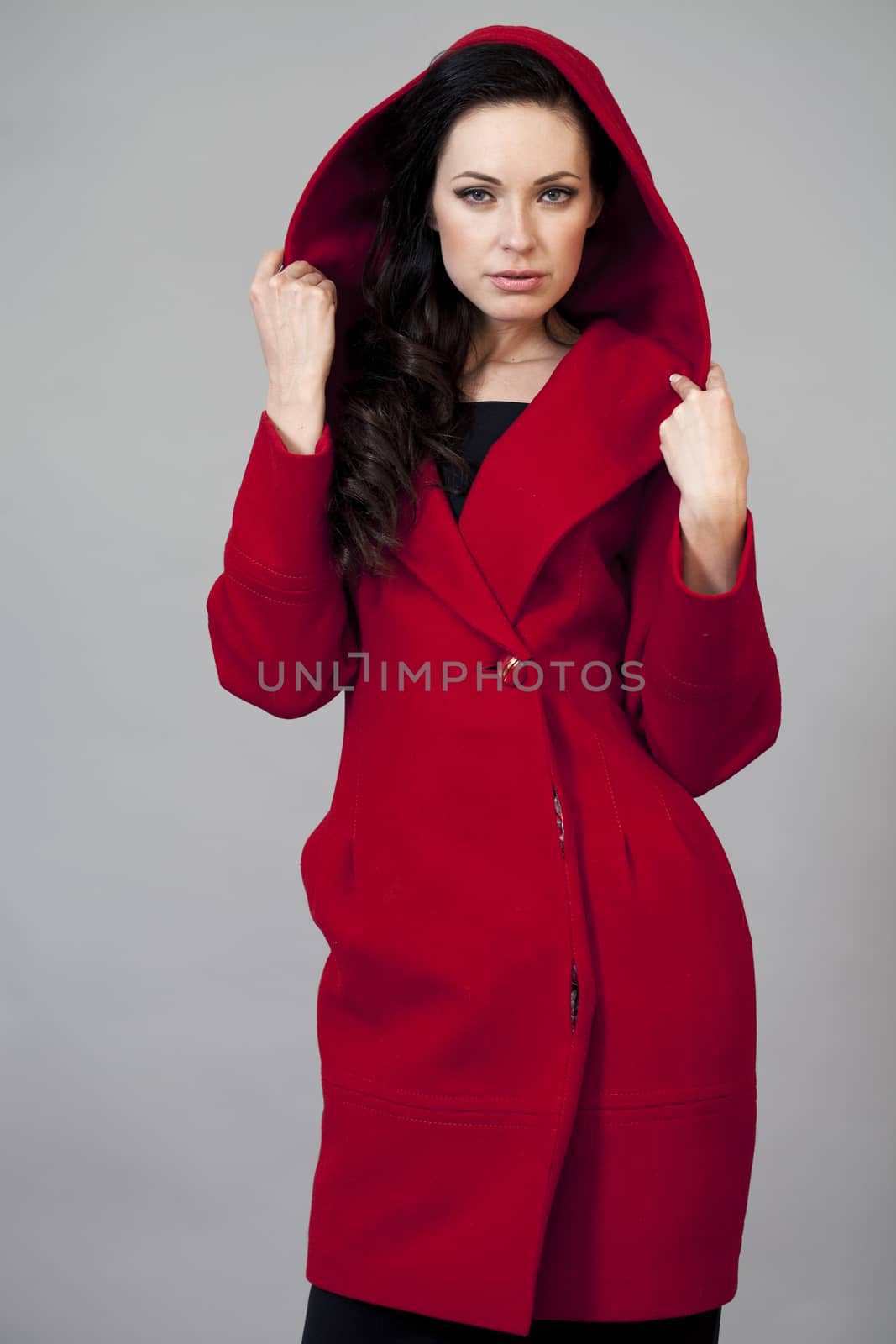 Beautiful young woman in red coat by andersonrise