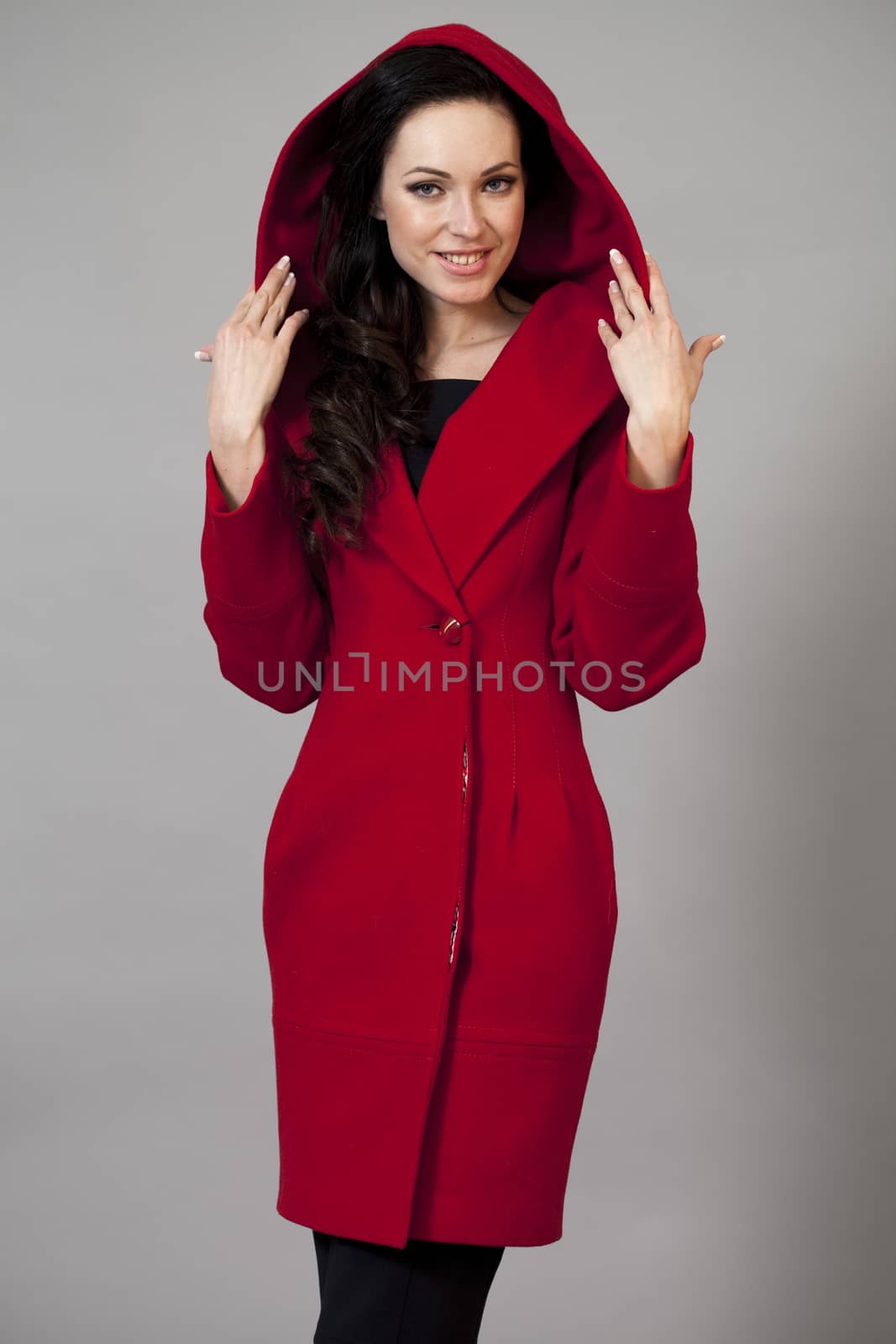 Beautiful young woman in red coat by andersonrise