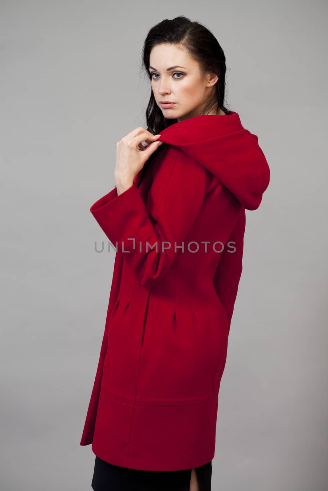 Beautiful young woman in red coat by andersonrise