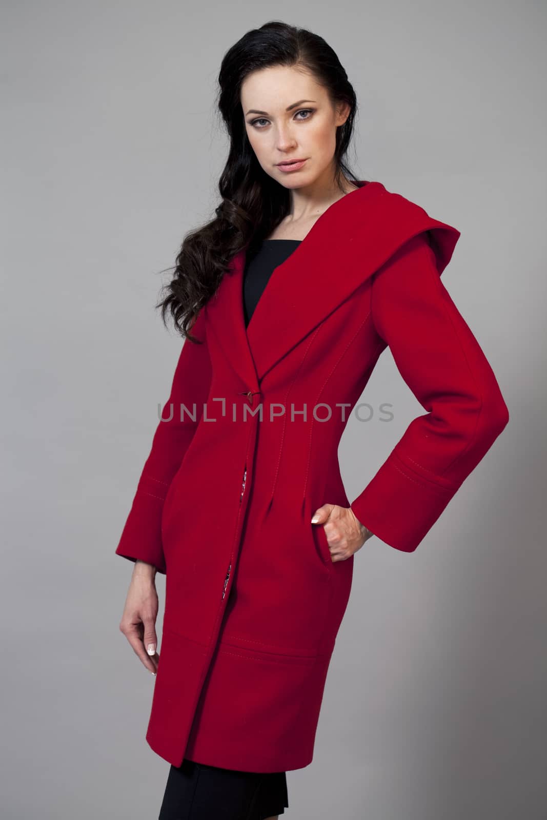 Beautiful young woman in a red coat with hood