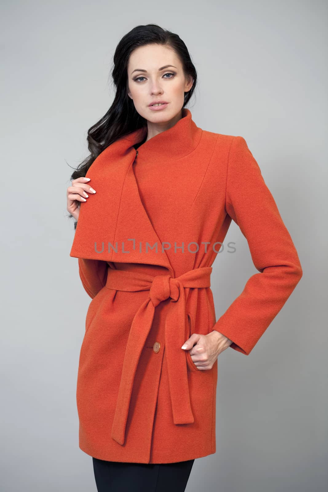 Beautiful women in a bright orange coat by andersonrise