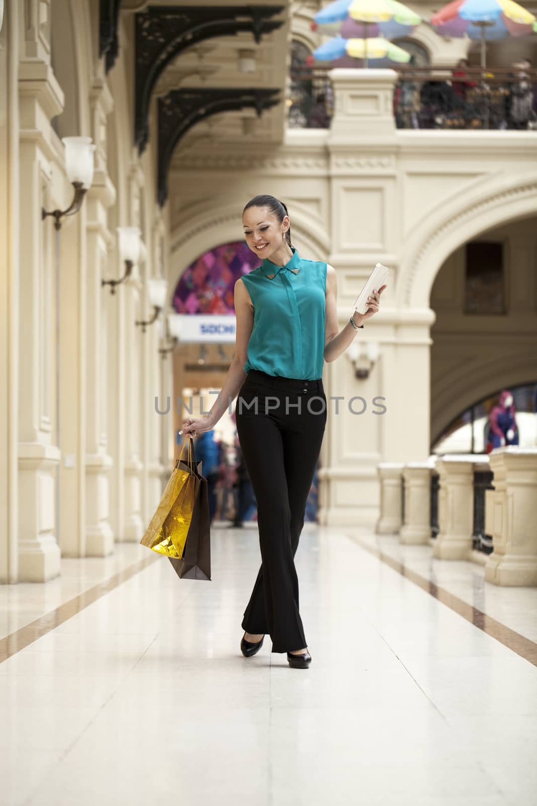 Happy young woman walking in the shop