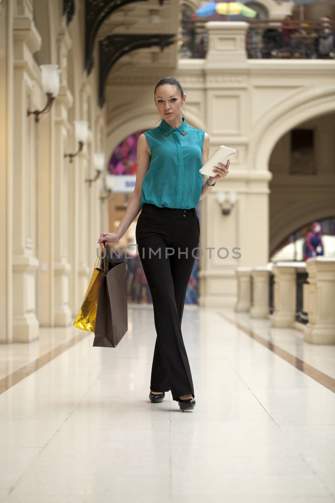 Beautiful young woman walking in the shop