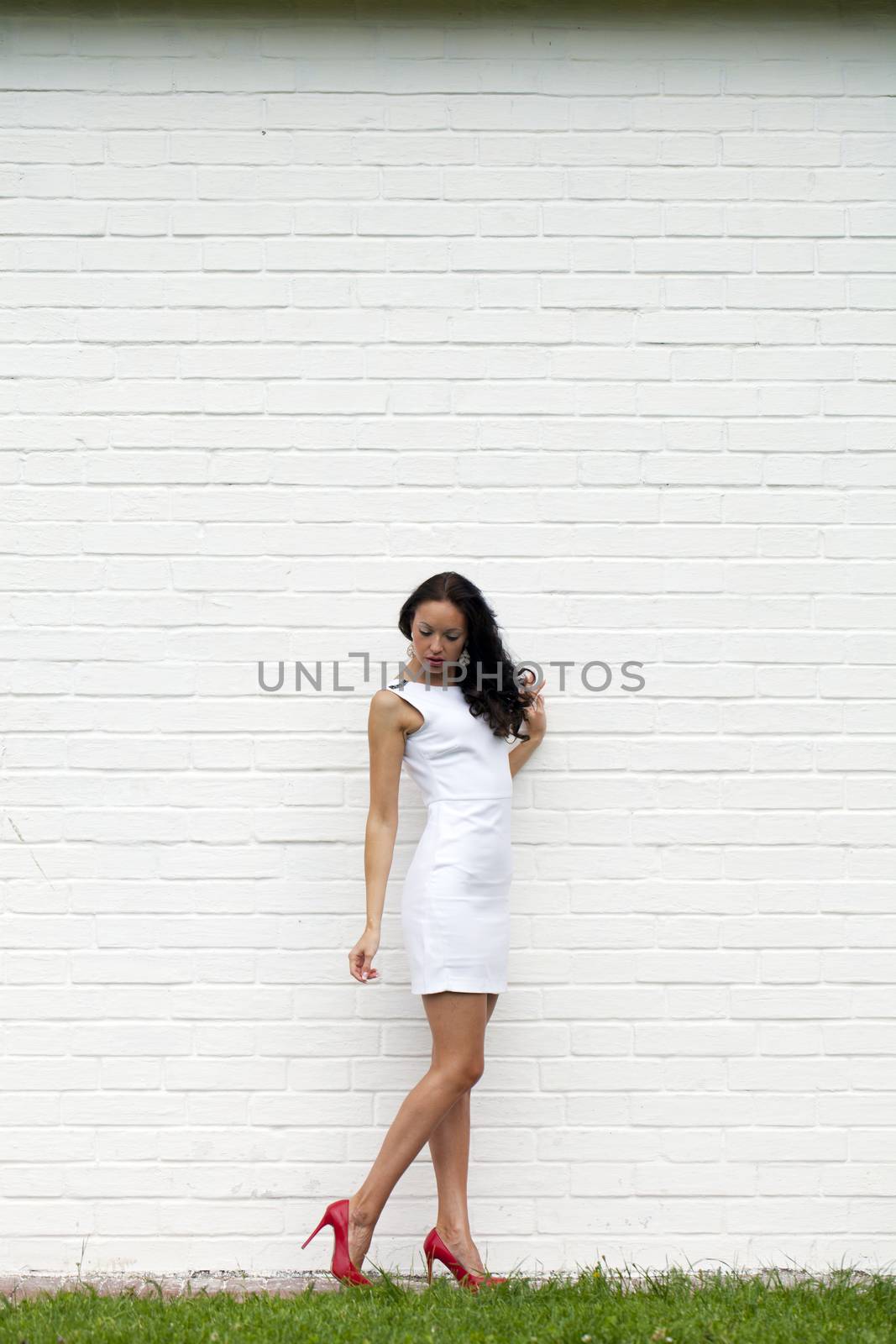 Portrait of young woman in sexy white dress by andersonrise