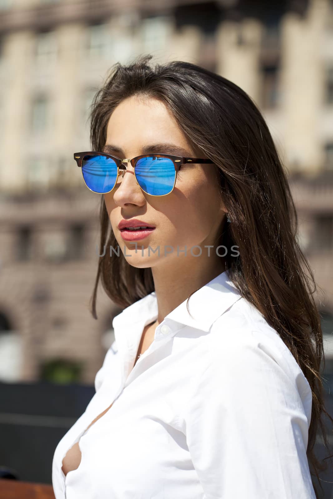 Business woman with blue mirrored sunglasses by andersonrise