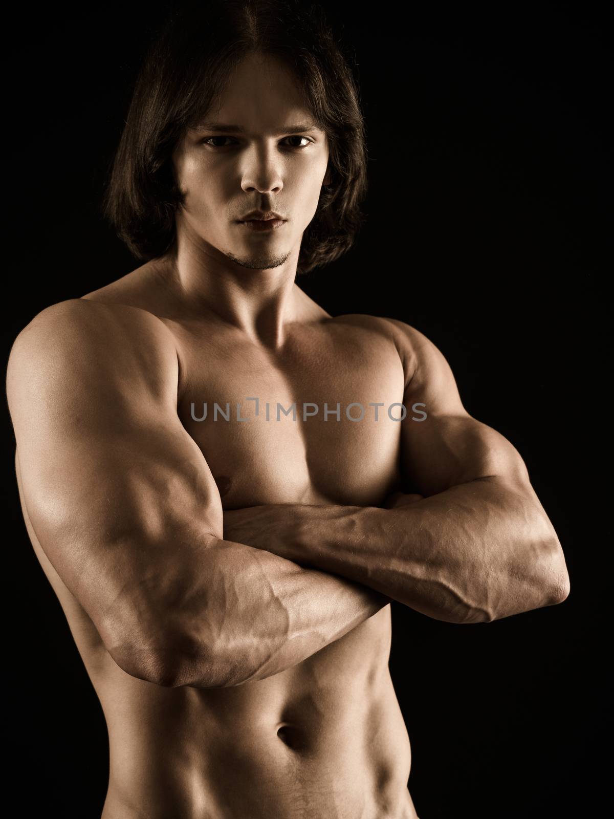 Muscular young man with arms crossed by sumners
