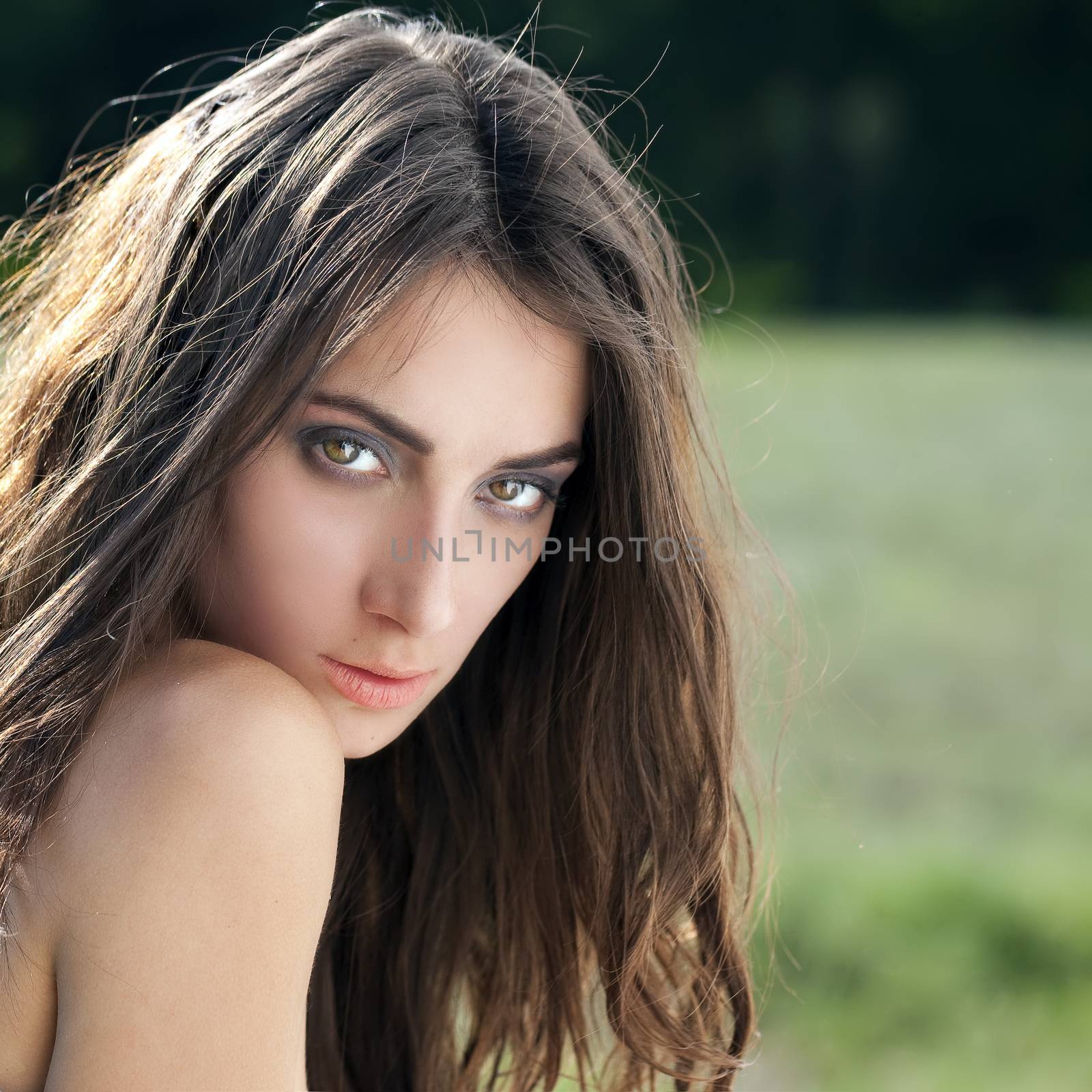 Portrait of a beautiful sexy young brunette woman in summer park