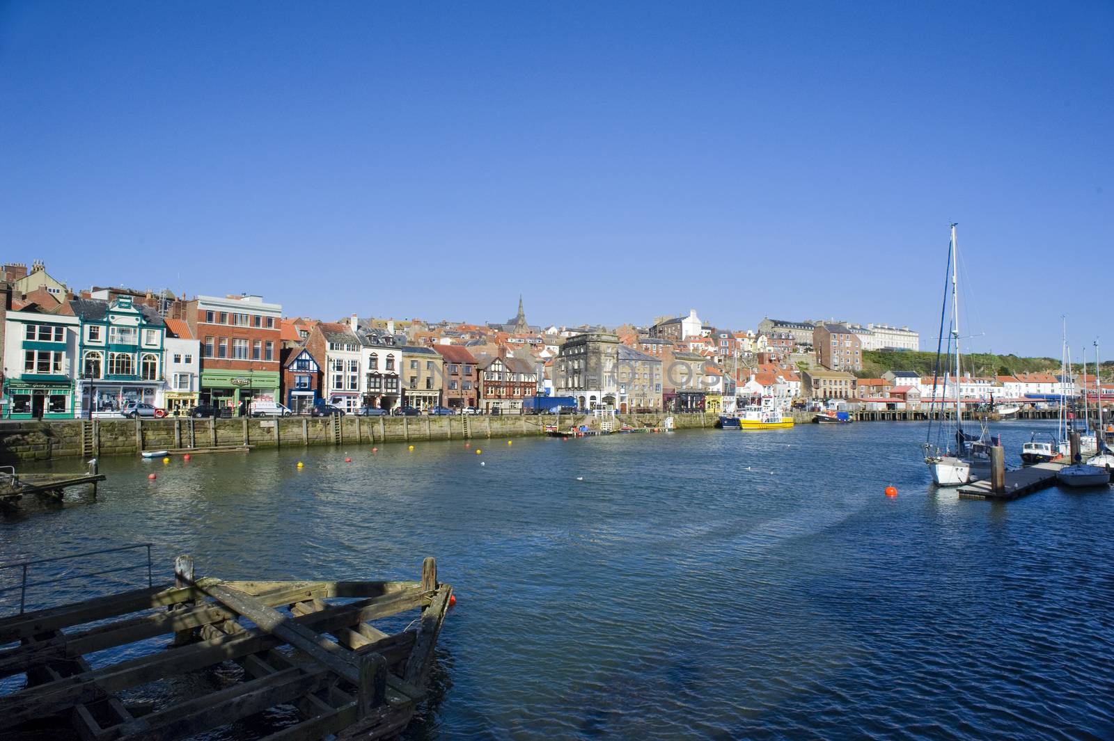 Middle Harbour, Whitby, North Yorkshire with the waterfront buildings and fishing quays on the banks of the River Esk