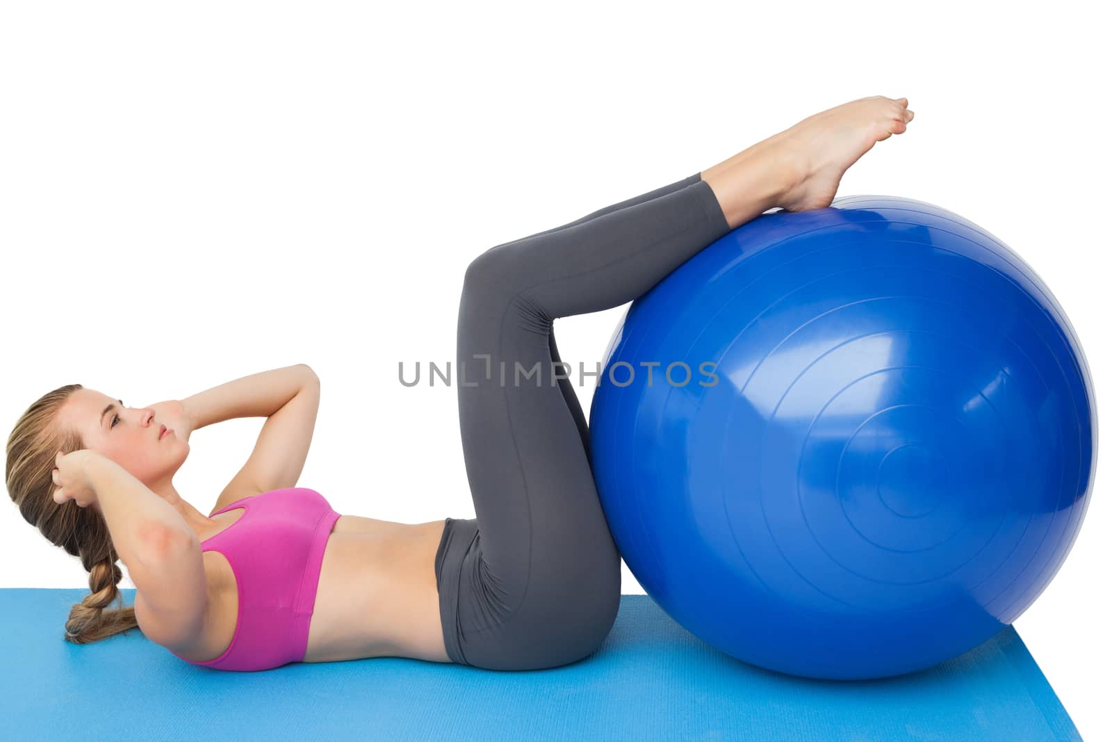 Side view of a fit woman exercising with fitness ball by Wavebreakmedia