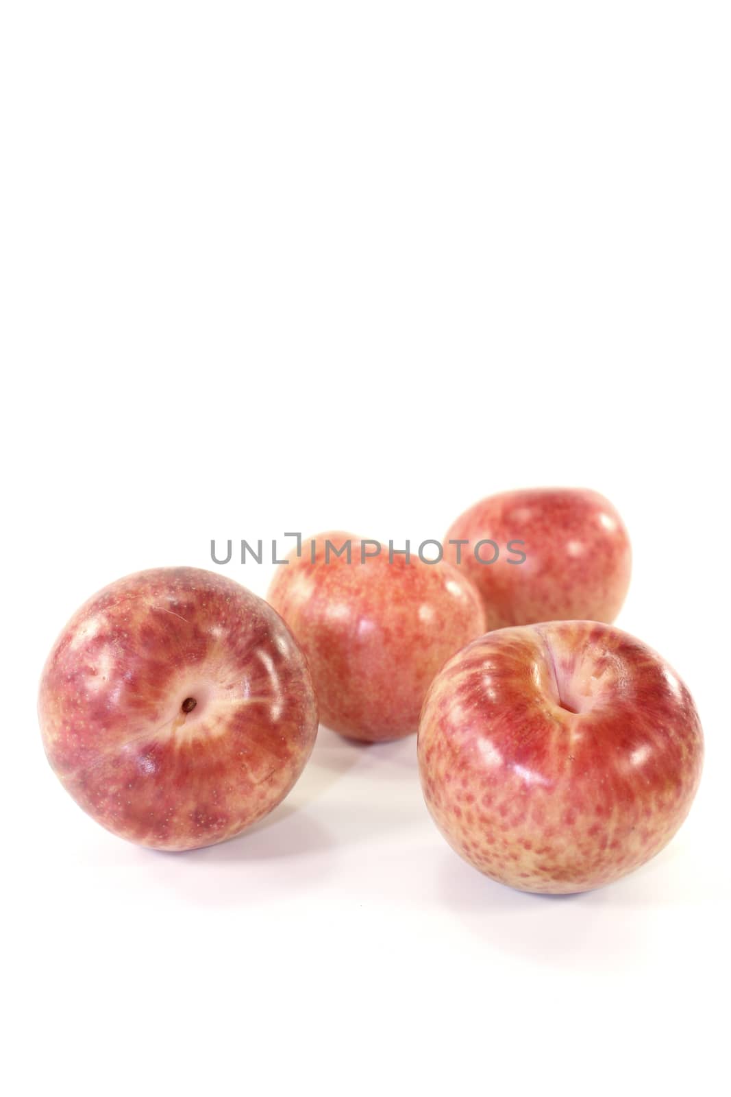 delicious orange-red pluots on a light background