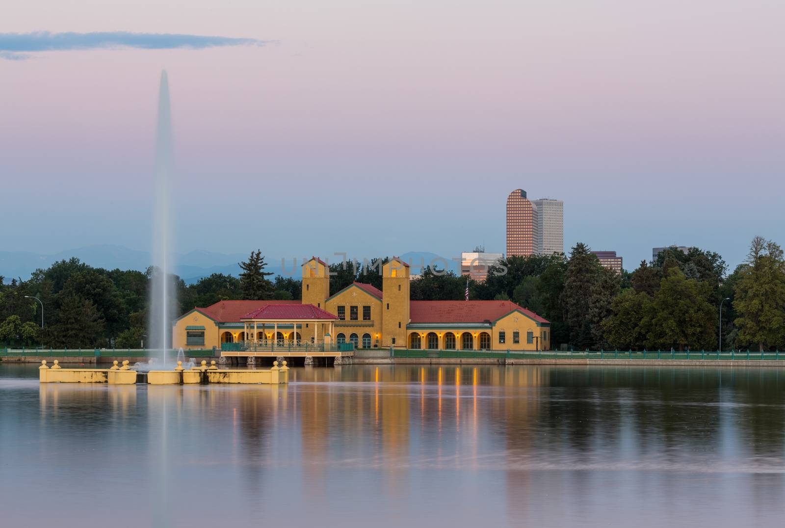 Fountain and Boathouse at Ferril Lake with the city skyline of Denver Colorado in background just before sunrise
