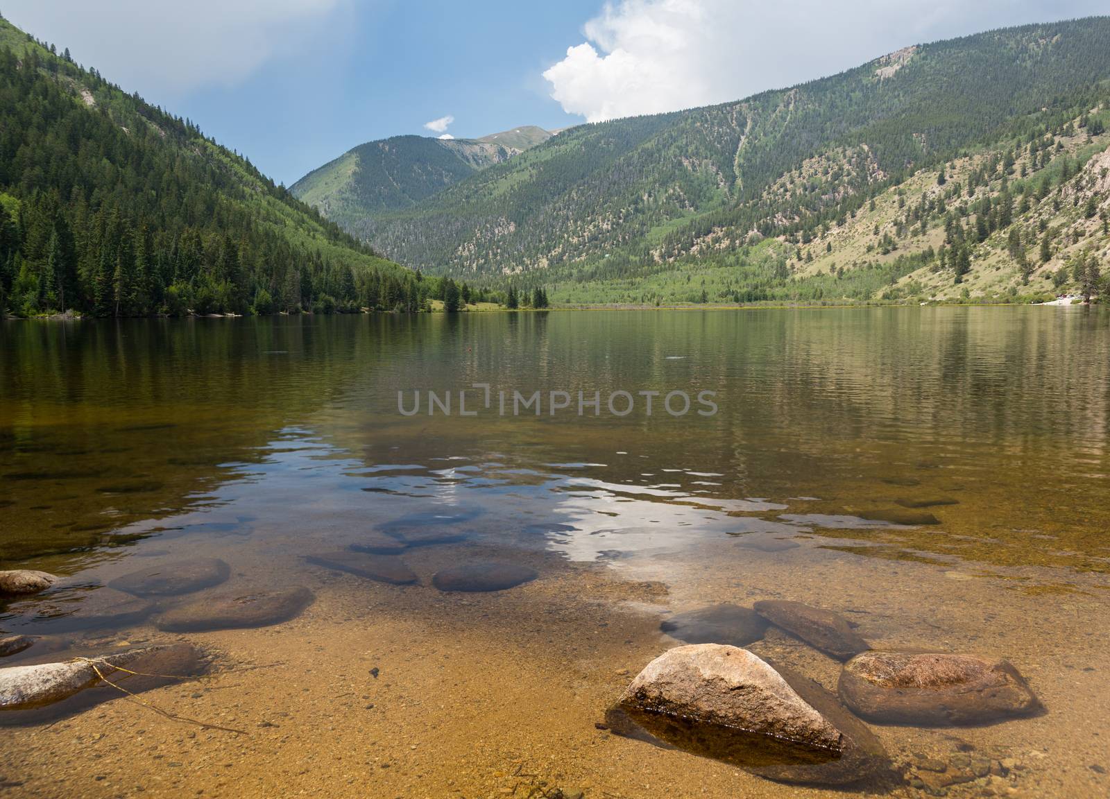Cottonwood lake in the valley before pass over mountains on clear calm day with the lake stretching off to distance