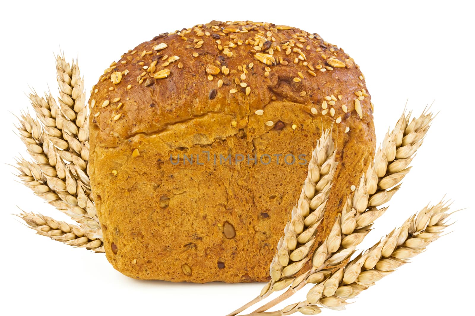 A loaf of bread with sunflower seeds, sesame seeds, grains of wheat and spikelets of wheat on a white background