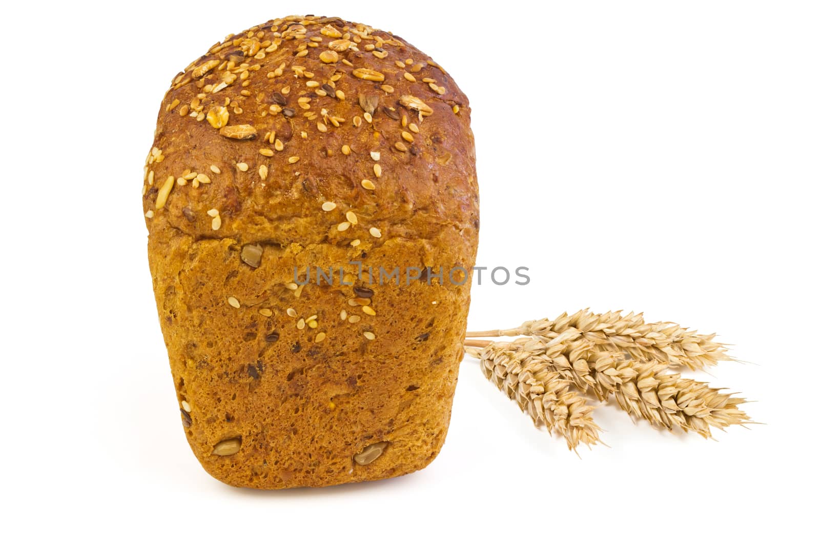 A loaf of bread with sunflower seeds, sesame seeds, grains of wheat and spikelets of wheat on a white background