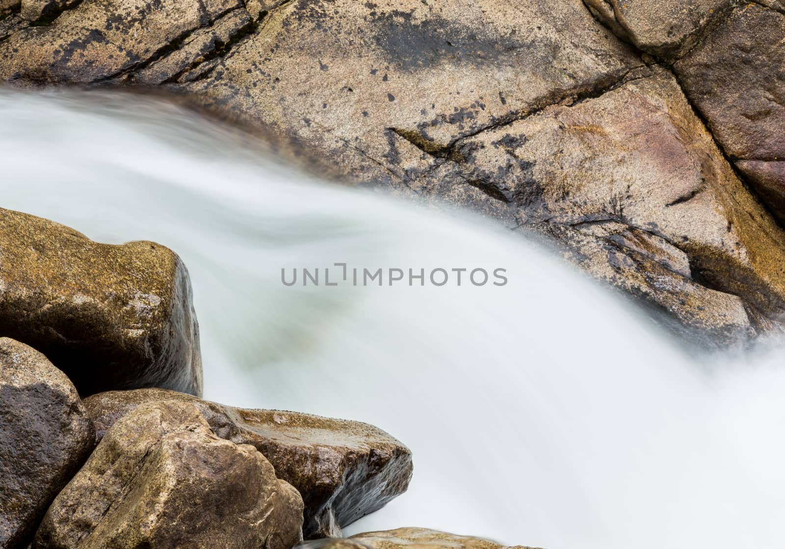 Water cascading between granite rocks in simple blurred motion images of waterfall