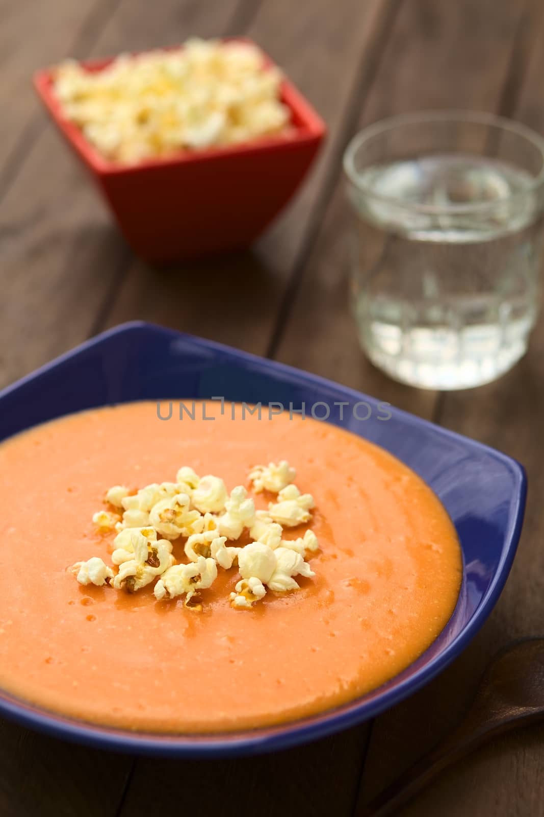 Ecuadorian tomato and potato cream soup served with popcorn on top (Selective Focus, Focus on the front of the popcorn on the soup)