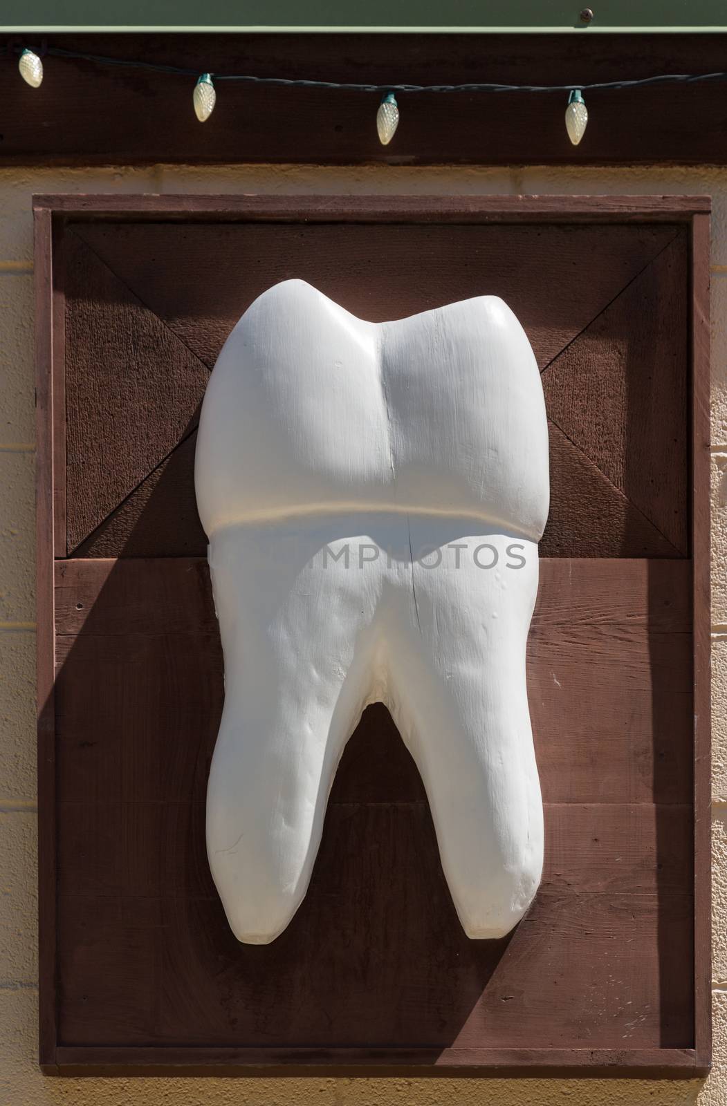 Large wooden tooth sign outside dentist by steheap