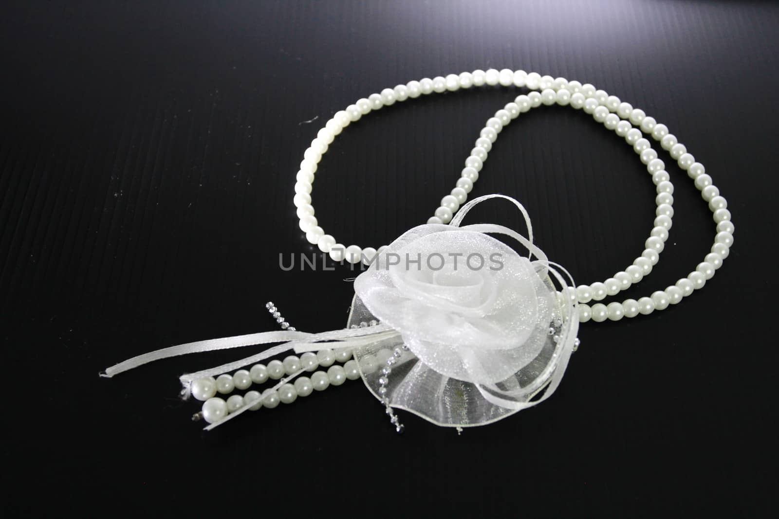 This is a necklace made from fabric and beads.In the concept of white accessorie.