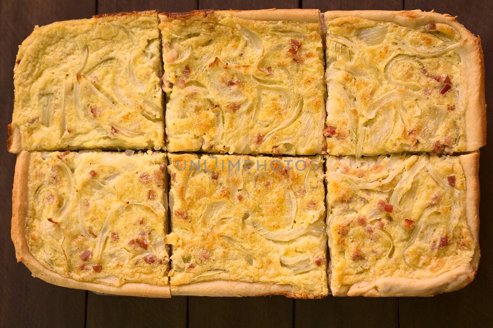 Pieces of traditional German Zwiebelkuchen or onion cake, made of a yeast dough and topped with onions and bacon in cream sauce (Selective Focus, Focus on the two middle pieces) 