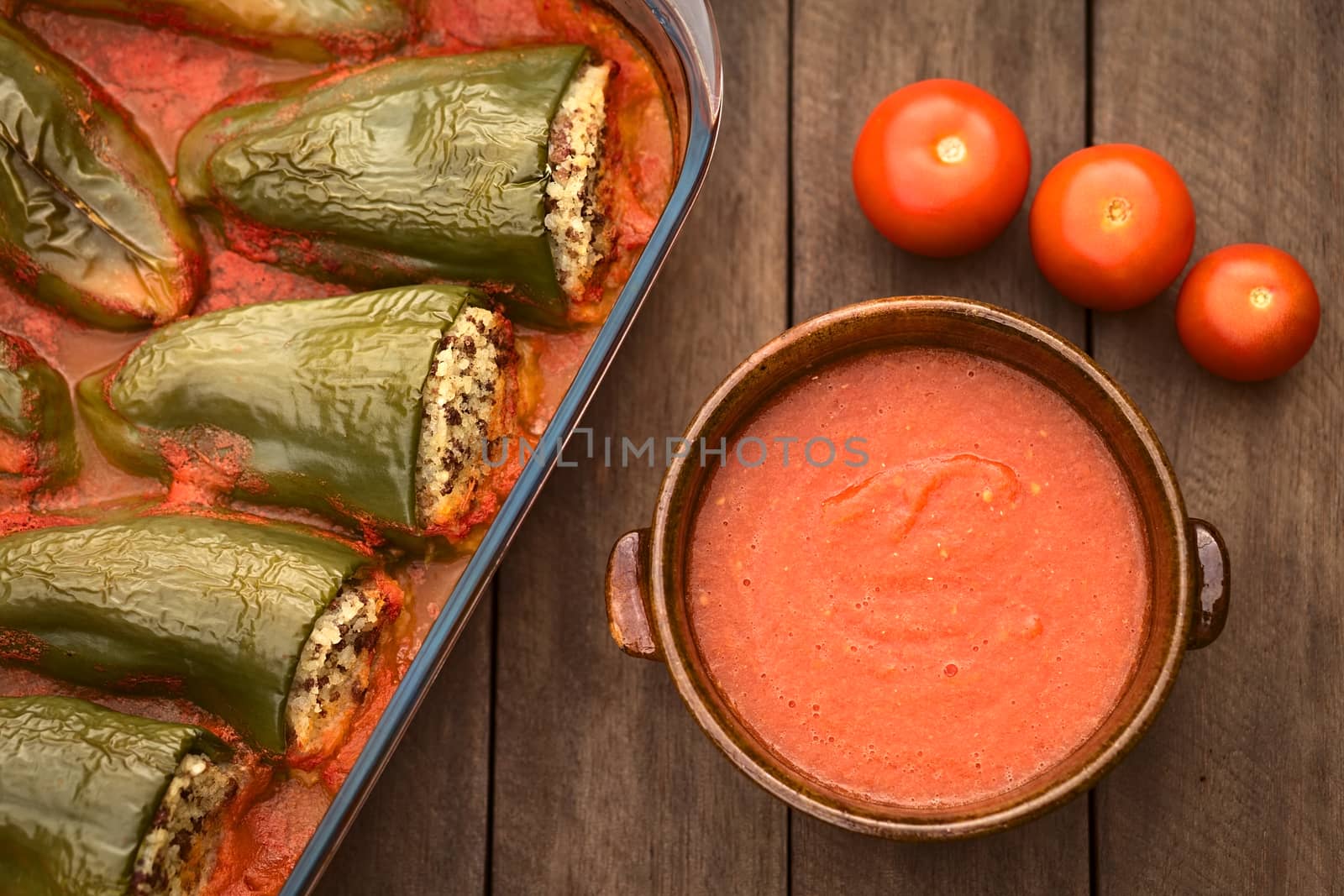 Hungarian baked pepper filled with mincemeat and rice eaten with tomato sauce (Selective Focus, Focus on the tomato sauce and the top of some of the filled peppers)