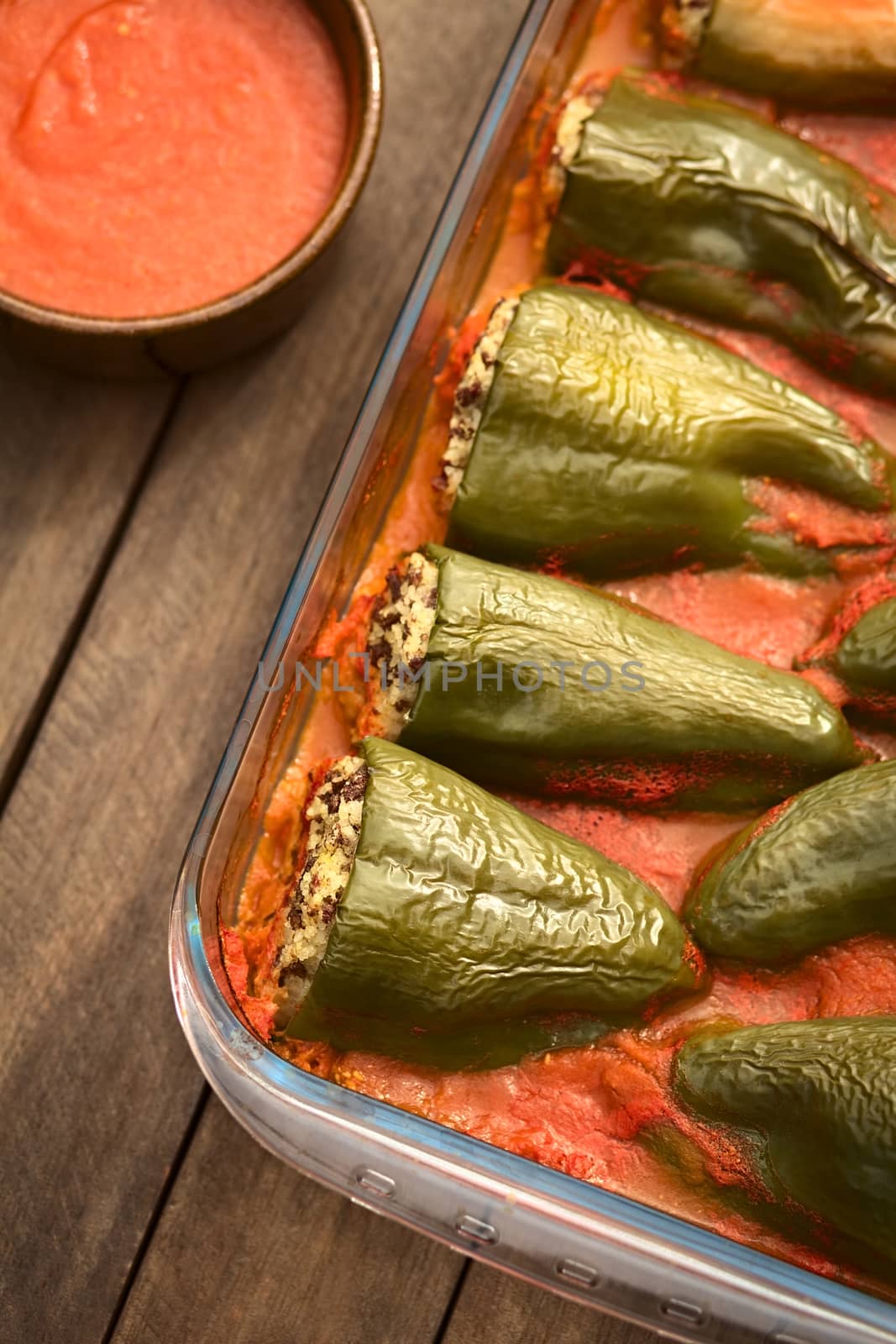 Hungarian baked pepper filled with mincemeat and rice eaten with tomato sauce (Selective Focus, Focus on the top of the filled peppers on the bottom of the image)