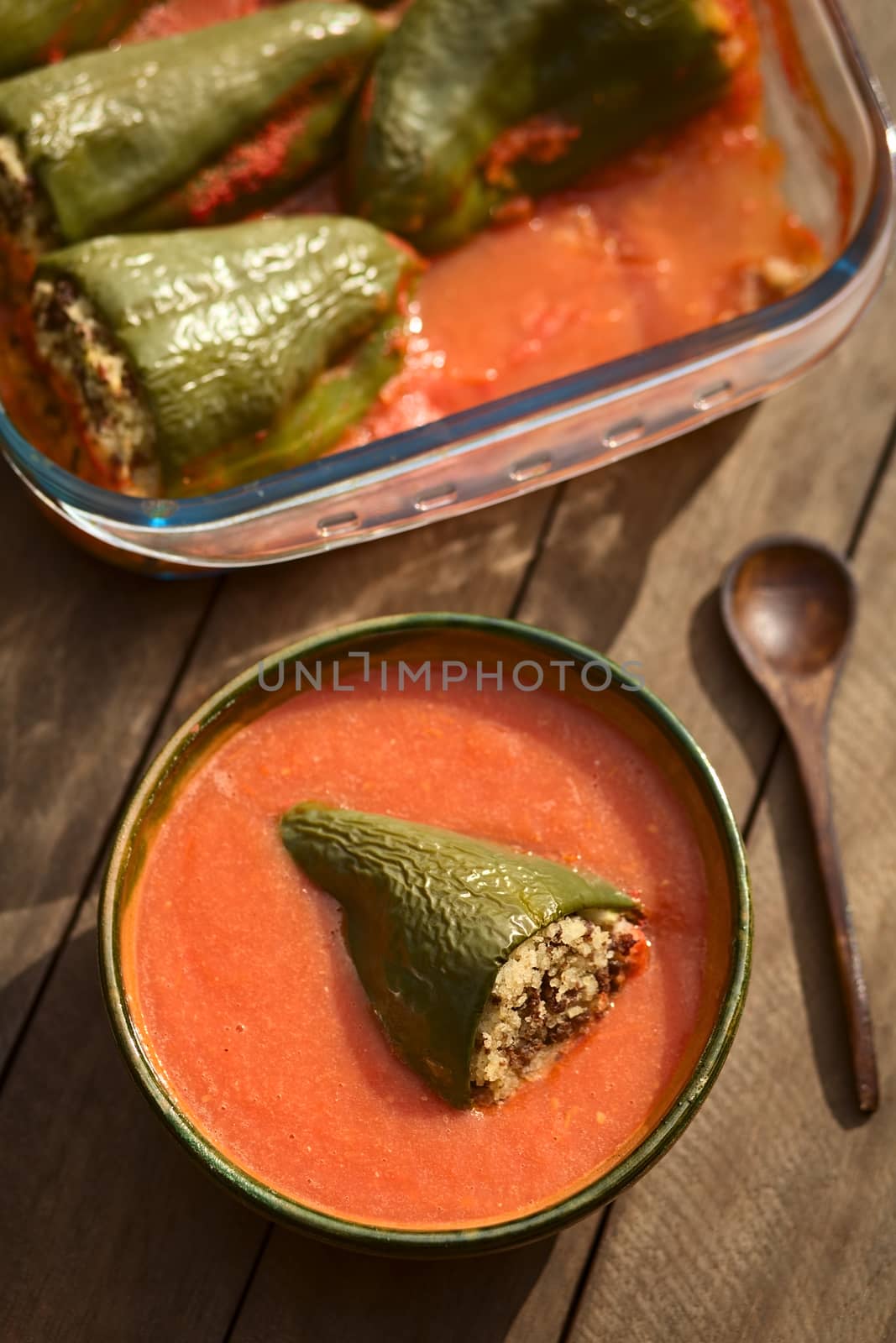 Hungarian baked pepper filled with mincemeat and rice eaten with tomato sauce (Selective Focus, Focus on the top of the filled pepper in the bowl)