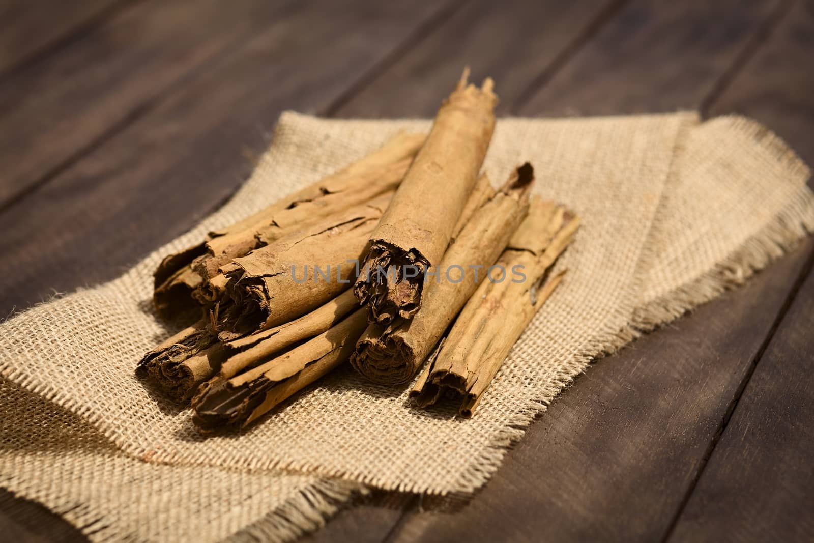 Cinnamon sticks on jute fabric (Selective Focus, Focus on the front of the upper sticks) 