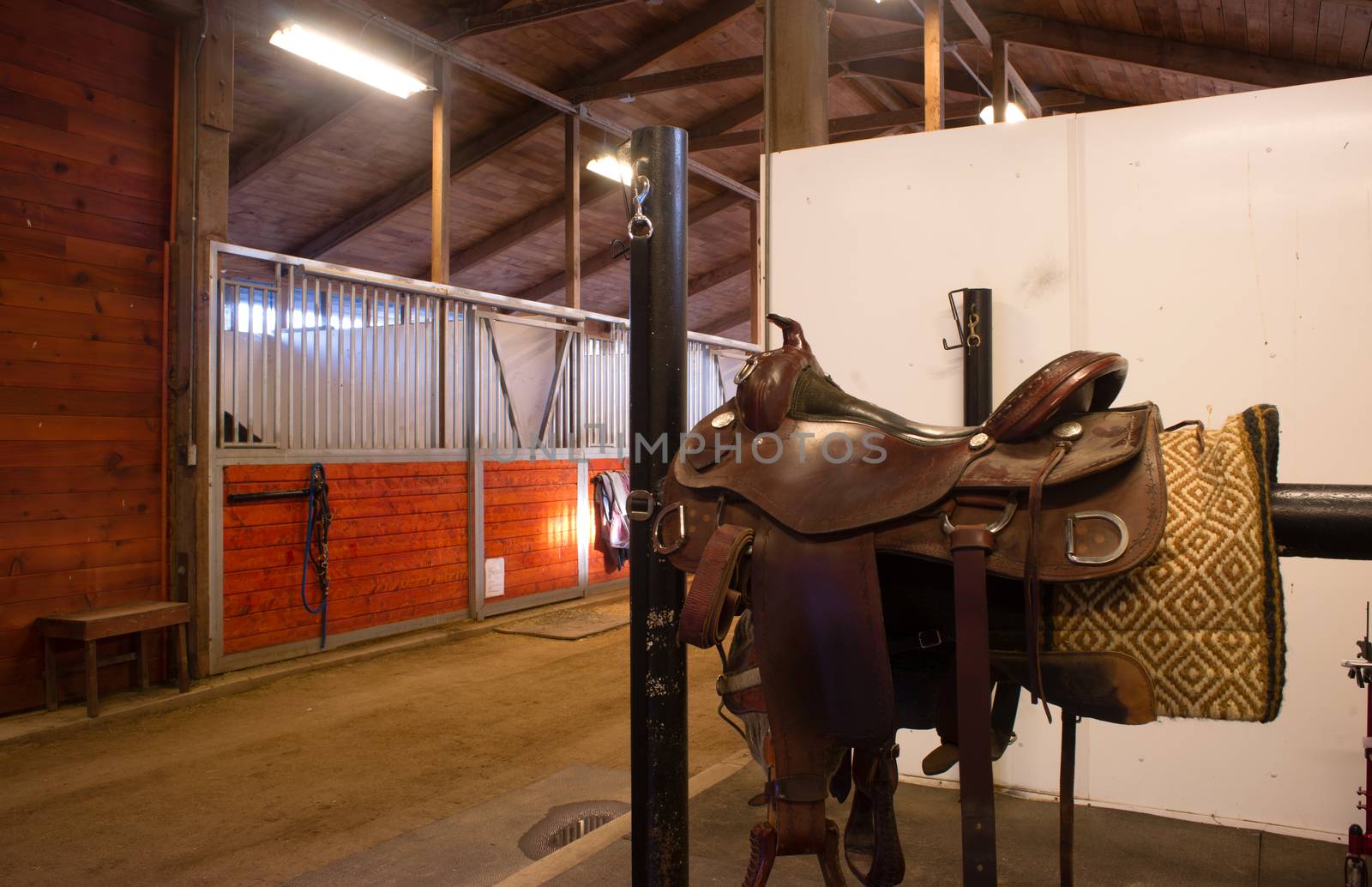 A saddle waits to be mounted on horses back at stables